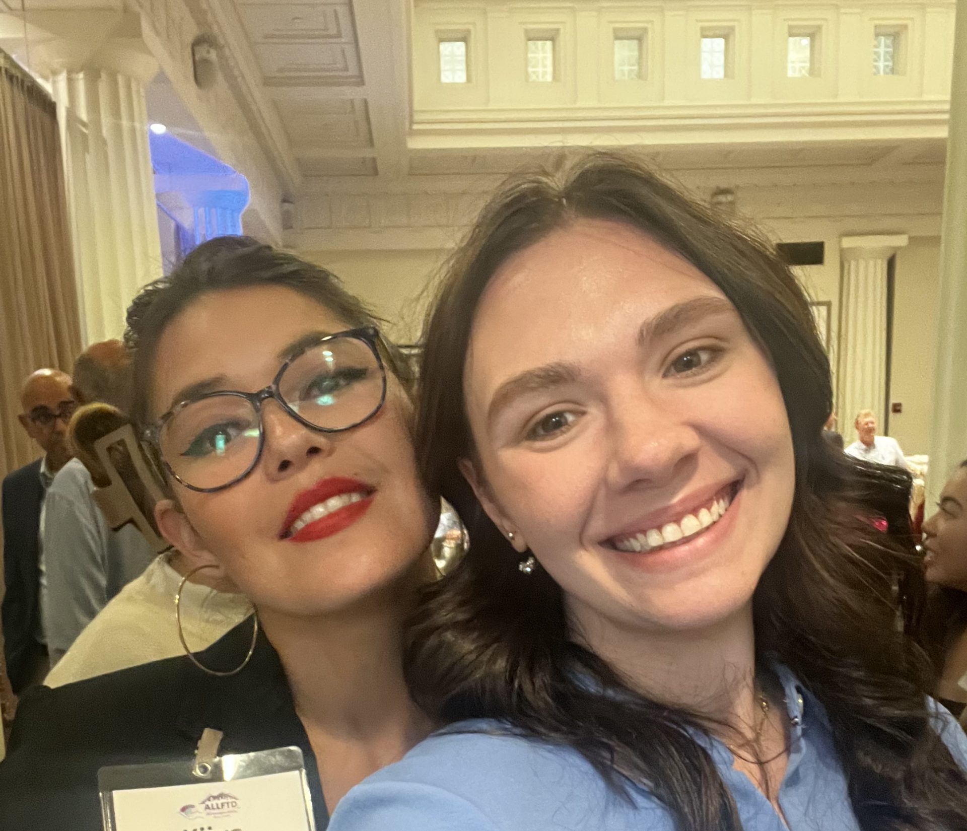 two women smiling in a professional setting